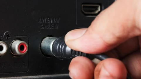 Man connecting an antenna cable to a television Stock Footage 344363473