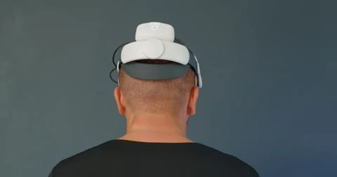 Man connecting battery on Virtual Reality headset. Back view. Stock Footage 257585773