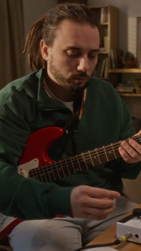 Man Connecting Cable to Audio Interface for Playing Electric Guitar Stock Footage 337544245