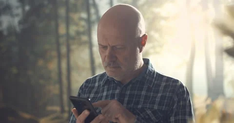 Man connecting with his smartphone in a forest Stock Footage 151159680