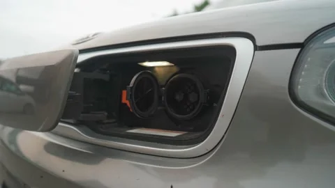 Man Connecting A Power Supply Cable Into An Electric Car For Charging An EV Stock Footage 156791067