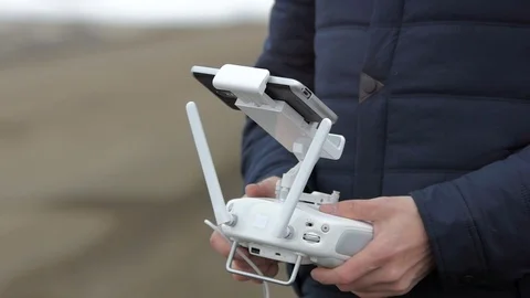 Man connecting the remote controller and the mobile phone by the wire. Stock Footage 69960269