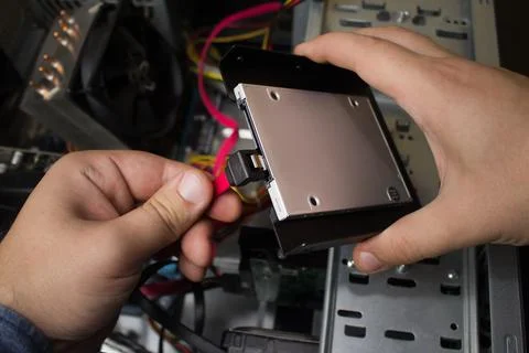 Man connecting SSD drive. Stock Photos