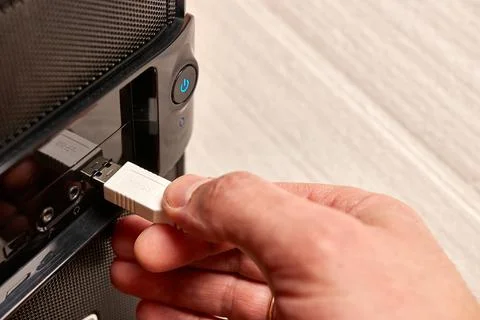 The man connects the cable to the computer via USB. Information transfer and sto Stock Photos