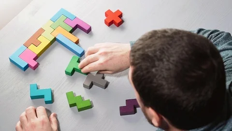 A man connects different geometric shapes, the concept of concentration. Stock Footage 101161603