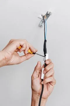 A man connects the electrical cord of a ceiling light Stock Photos