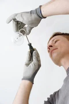 Man connects the light bulb. Stock Photos