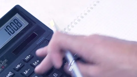 Man considers on the calculator and making notes in a notebook Stock Footage 81262662