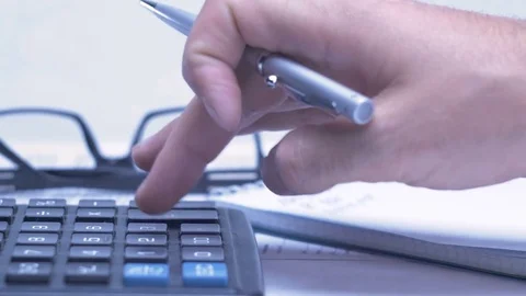 Man considers on the calculator and making notes in a notebook Stock Footage 81264441