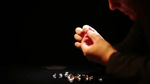 Man considers diamonds through a magnifying glass Stock Footage 40252982