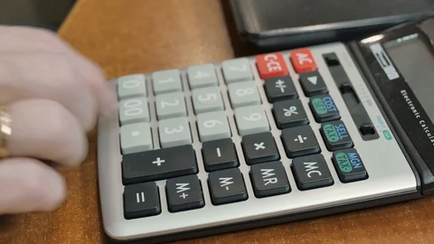 A man considers finances using a multifunctional professional calculator. close Stock Footage 128141919