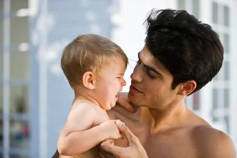 Man consoling his crying son Stock Photos