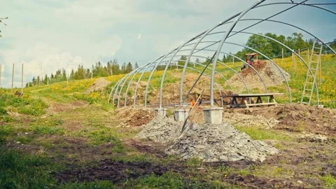 Man Constructing Greenhouse Frame With Tractor Shovel Outdoors Stock Footage 341553304