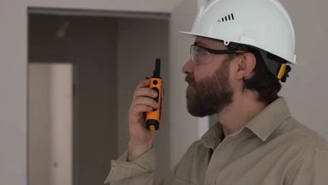 A man from the construction commission is talking on a walkie-talkie Stock Footage 234920182