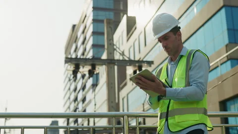 Man construction engineer examines project via tablet on footbridge Stock Footage 299884361