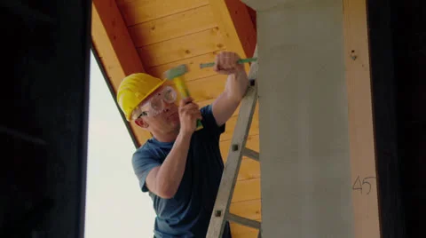 Man in construction site, manual worker on ladder using hammer Video stock 25455727
