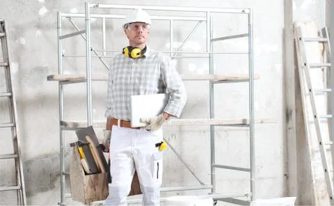 Man construction worker with computer and tools box wear gloves, hard hat, gl 스톡 사진
