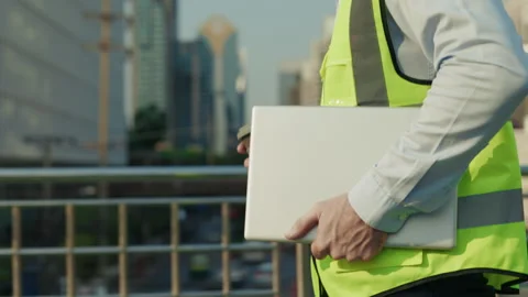 Man construction worker holds cup of coffee and laptop Stock Footage 308464737