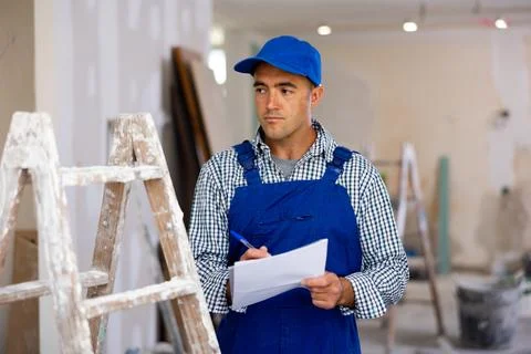 Man construction worker planning works in apartment Stock Photos