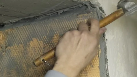 Man construction worker removes old material from room wall Stock Footage 304409100