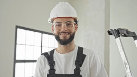 Man construction worker wearing hardhat, safety glasses and apron smiles wh.. Stock Footage 337371698