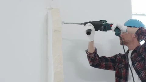 Man construction worker wearing red checkered shirt, blue hard hat and Stock Footage 310402367