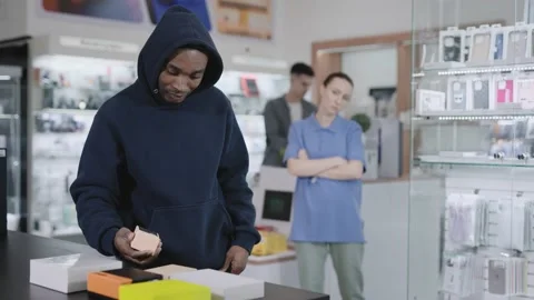 A man in a consumer electronics and gadgets store commits a theft. Crime and Video stock 223129533