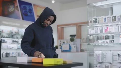 A man in a consumer electronics and gadgets store commits a theft. Crime and 스톡 동영상 229171754