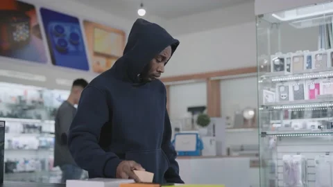A man in a consumer electronics and gadgets store commits a theft. Crime and Video stock 229548808
