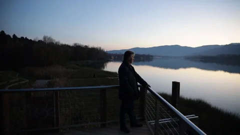 Man contemplating the lake at sunset Stock Footage 101740062