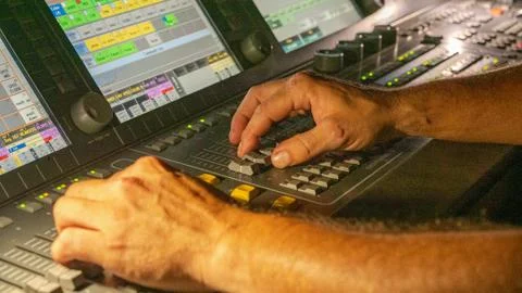 Man control lights from console at live concert Stock Photos