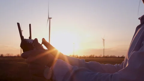 Man with a control panel, background of a field of wind turbines Stockbeeldmateriaal 135011777