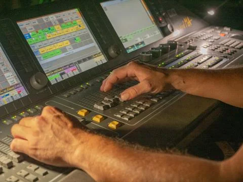 Man controling lights from console at live concert Stock-Fotos