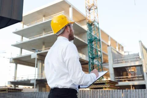 Man Controlling Building. Builder making marks in Clipboard. House Building Stock Photos