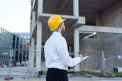 Man Controlling Building. Builder making marks in Clipboard. House Building Stock Photos