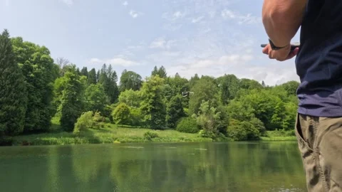 Man controlling Drone next to a lake, summer time outdoor Stock-Footage 310956537