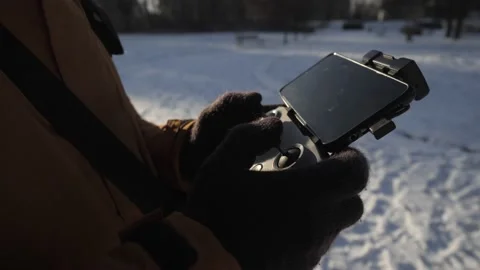 The man is controlling the drone with smartphone Stock Footage 237115377