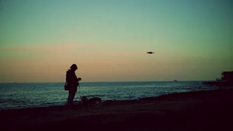 Man Controlling Flying Drone On a night beach Video stock 233290460