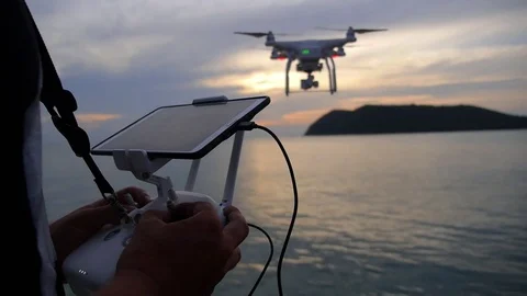 Man Controlling Flying Drone Using Console and Smartphone Video stock 71790883