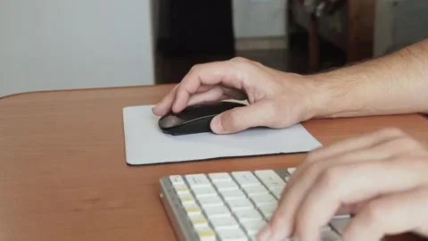 Man controls computer mouse on desk with mat, scrolling and pressing buttons. Stock Footage 330541841