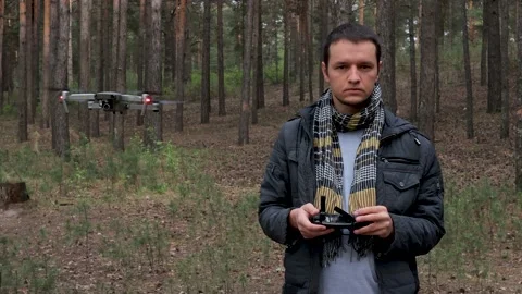 A man controls a drone in a pine forest. Stock Footage 131132929