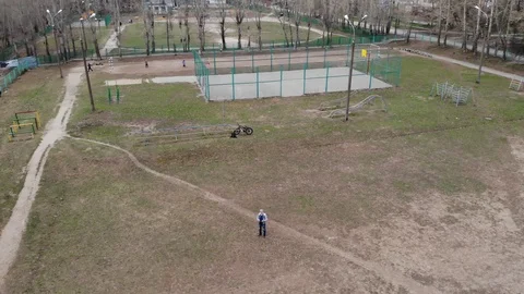 A man controls a drone in the Playground. Automatic flight mode. Stock Footage 107193277