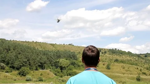 A man controls a drone at river Stock Footage 70129465