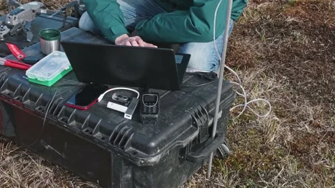 Man controls the drone through laptop in open air. Hydrologist are at work Stock Footage 165757897