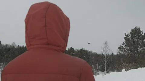 The man controls the drone.Quadcopter on the background of the winter forest Vídeos de archivo 103239992