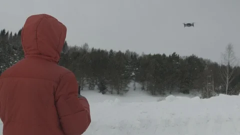 The man controls the drone.Quadcopter on the background of the winter forest Stock Footage 103240006