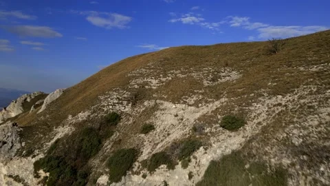 Man controls drones, drone returns to pilot in mountainous terrain Stock Footage 171289653