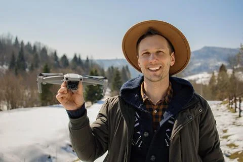 Man controls the flying drones in snowy forest winter. Stock Photos