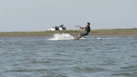 Man controls kiteboard and puts on safety leash slow motion Stock Footage 118992141