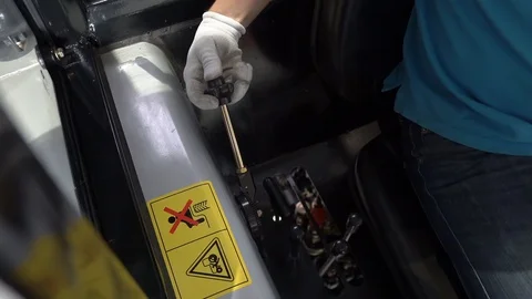 A man controls the levers of mounted attachment on agricultural machinery Stock Footage 128679597